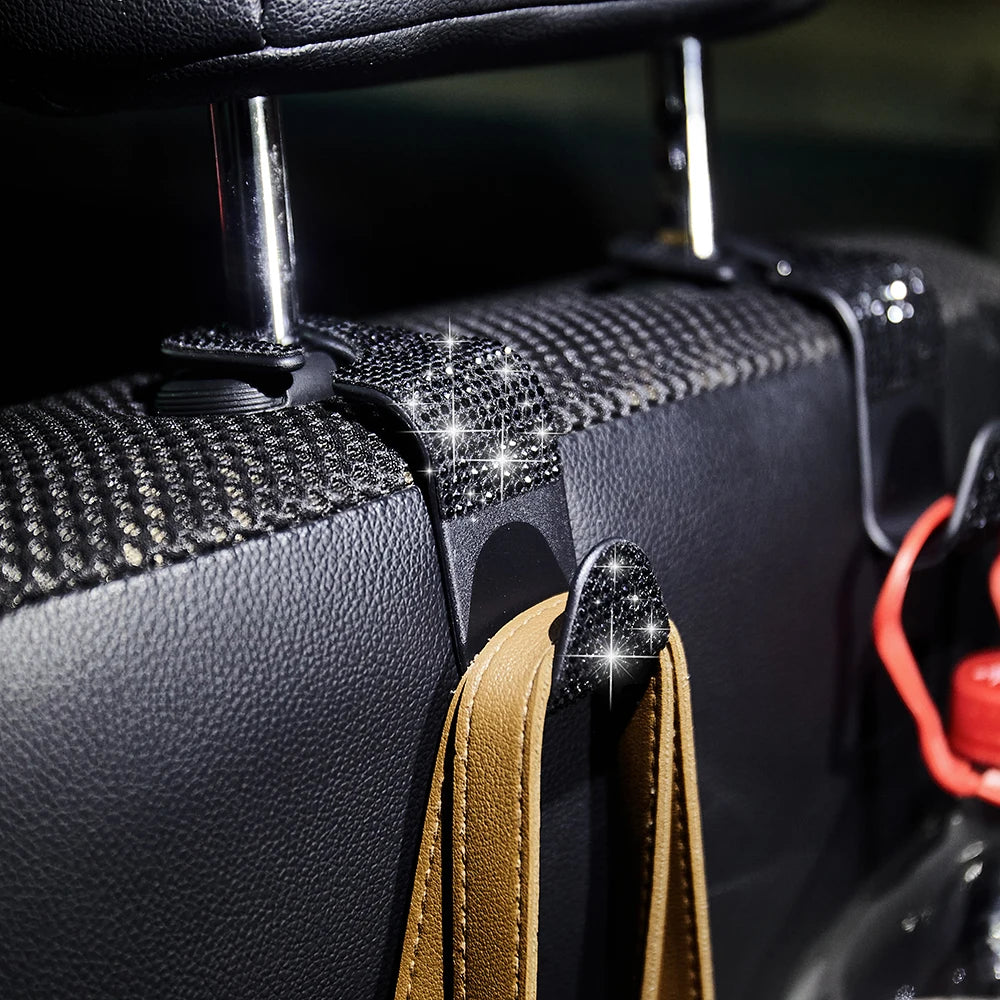 Close-up of black leather car hooks with diamond accents and tan strap for storage