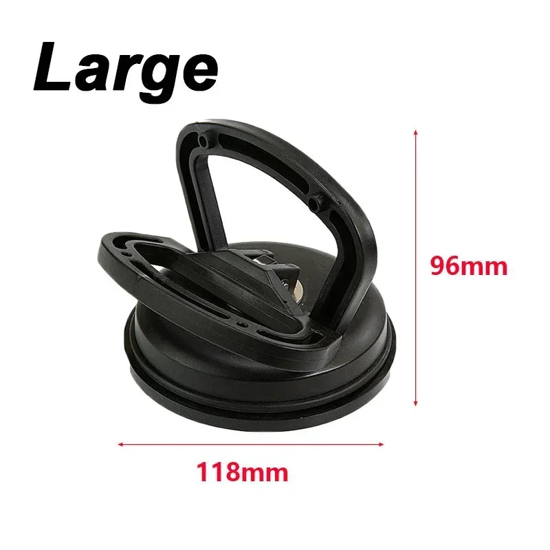 A black car dent glass suction removal tool with a handle and a circular base.