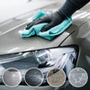 A hand wearing a black glove is cleaning a car's headlight with a teal cloth, showing before and after results.