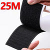 A hand is holding a black hook and loop tape strip for organization and DIY.