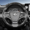 Close-up view of a Lexus steering wheel with carbon fiber trim and controls.