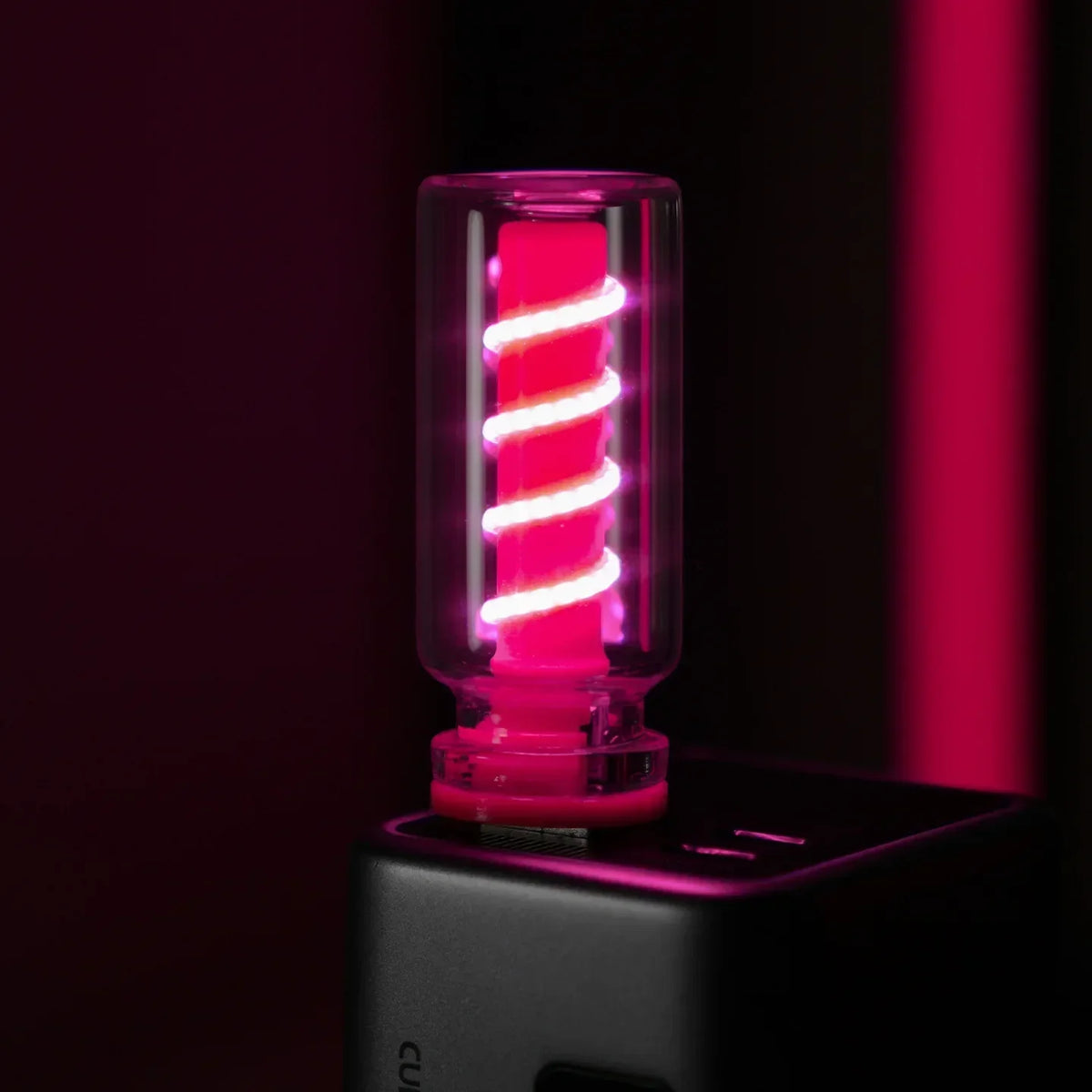 Gros plan d'une guirlande LED rose luminescente dans une lampe de nuit USB noire.