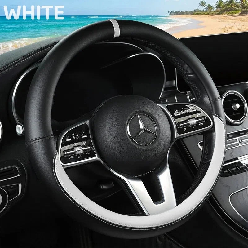 A black Mercedes steering wheel with a silver trim and leather wrap is shown inside a car cabin.
