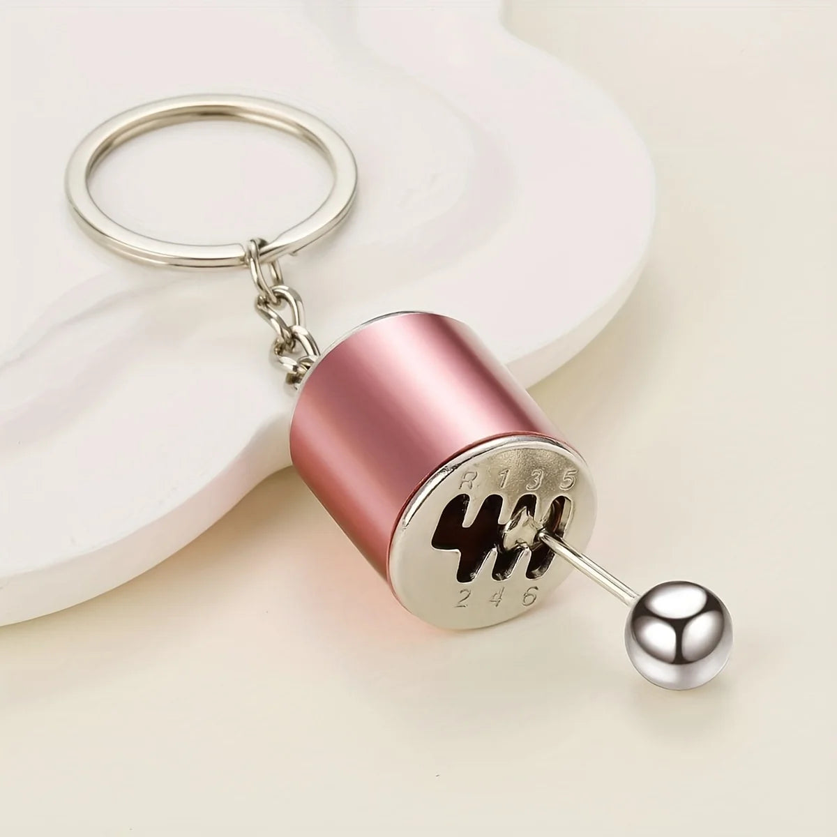 A pink cylindrical keychain with a silver ring and a metal pin featuring the text WWW on a white background.