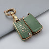 A gold-toned key fob case with a leather strap and a keyring is shown against a gray background.