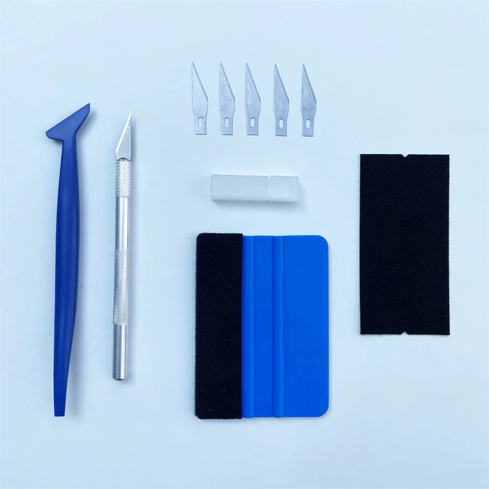A set of vinyl wrap tools including a blue tool, several metal blades, and black and blue protective film sheets.