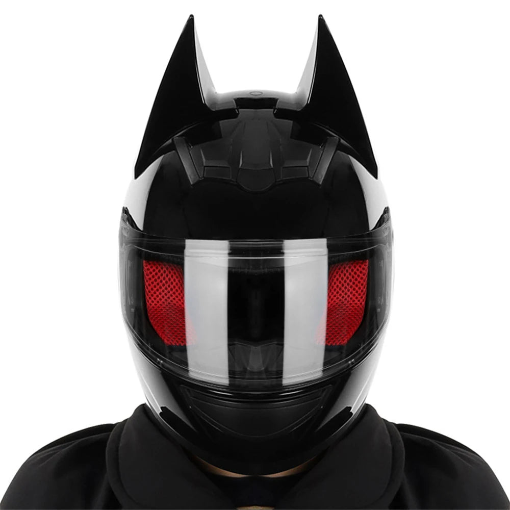 Black full face motorcycle helmet with prominent pointed horns and a red visor