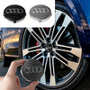 Tapaceros decorativos centrales para Audi y Porsche en negro y plata en una rueda de coche.