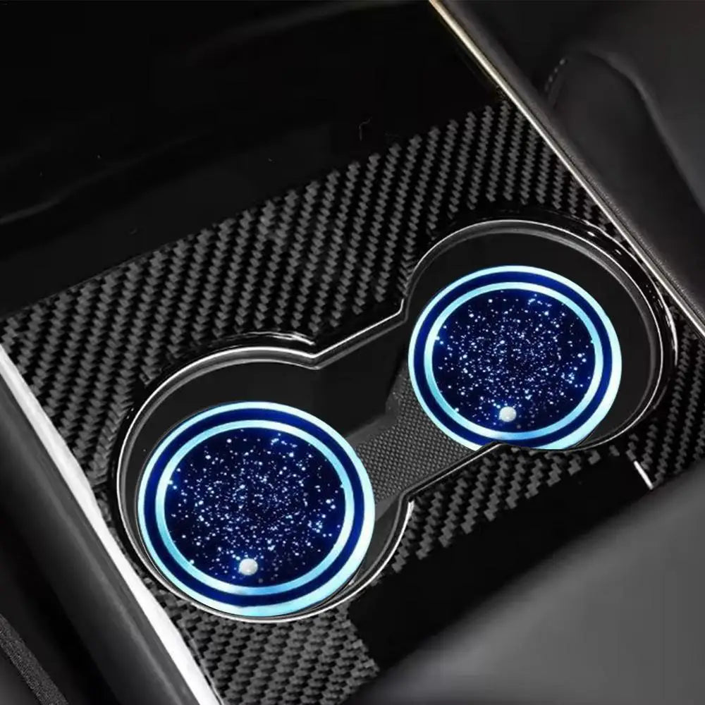 حصيران دائريان مع أضواء LED زرقاء موضوعان في حامل ذي ملمس كربون فايبر أسود.