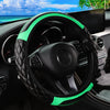 A black steering wheel with a green carbon fiber cover is shown inside a car cockpit.