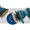 A close-up view of a blue abrasive interface pad and sanding disc with a white pad attached.