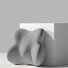 A gray ergonomic memory foam pillow shaped for car neck and lumbar support resting on a white surface.