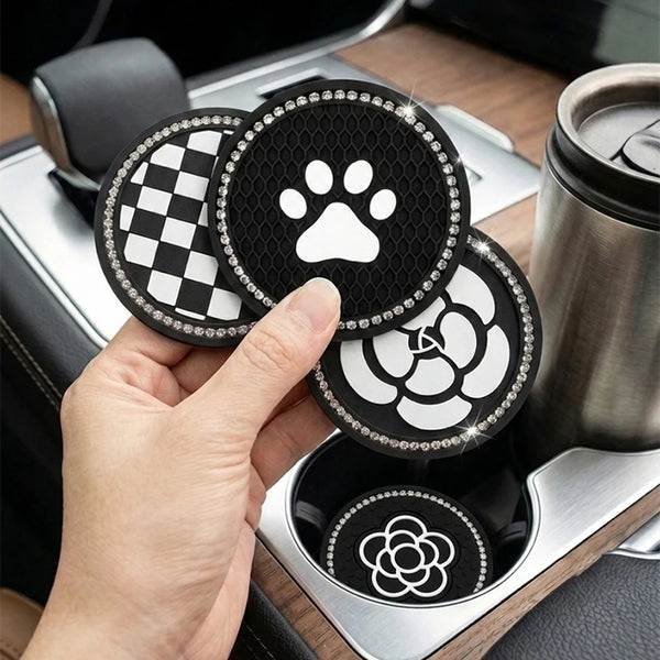 A hand holds three round coasters with different patterns, including a black and white checkered design and a paw print.