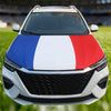 A white car hood decorated with the French flag design featuring blue, white, and red stripes.