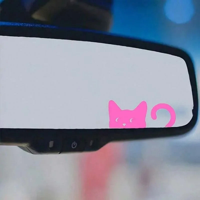 Pink cat decal placed on a black rearview mirror.