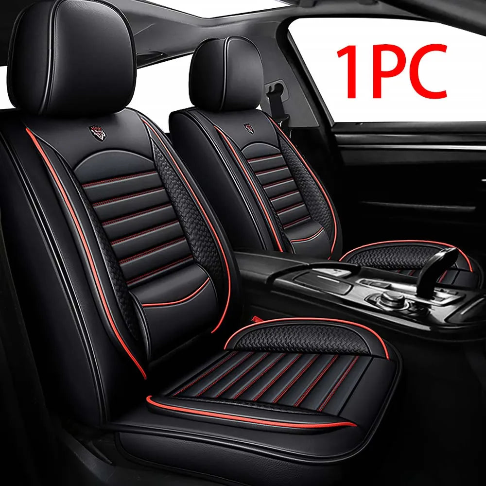 A pair of black leather car seat covers with red stitching installed in a vehicle interior.