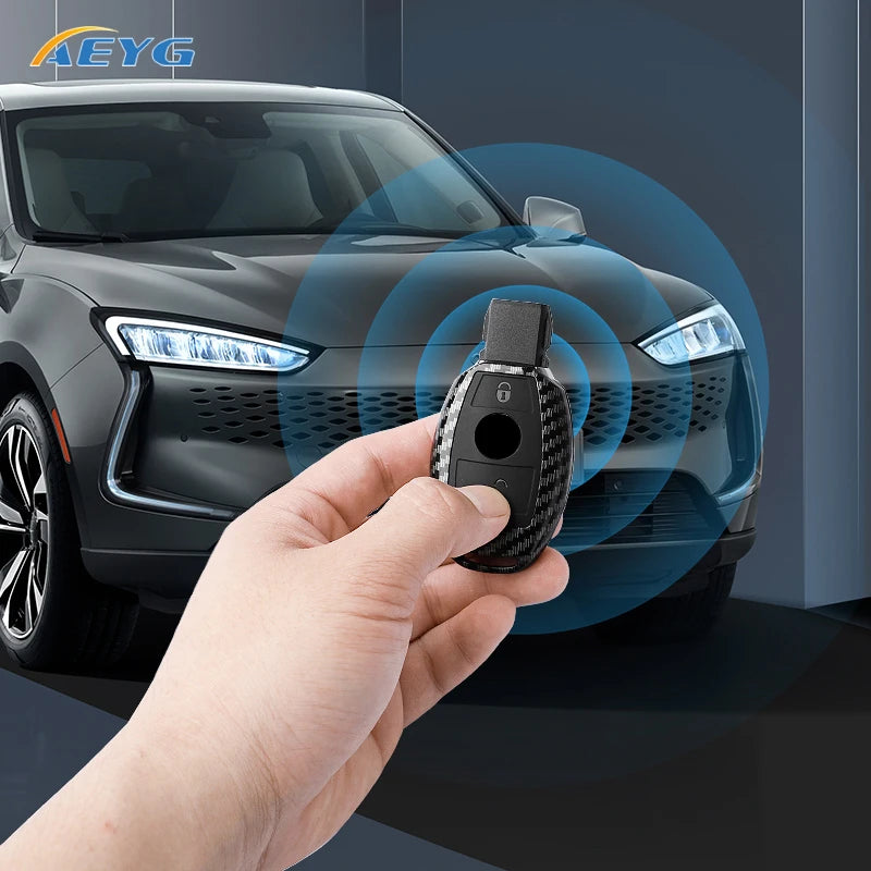 A hand holds a carbon fiber car key cover, demonstrating a product for Mercedes models.