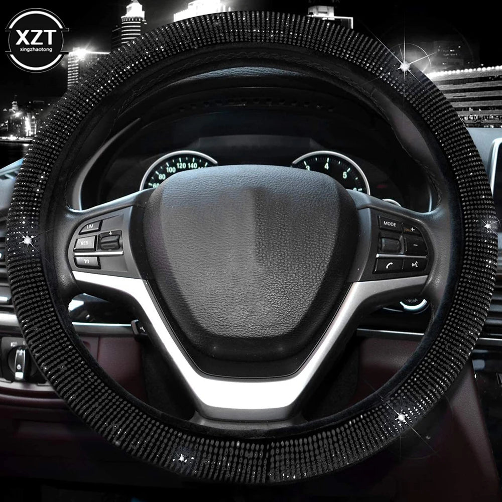 A close-up view of a black steering wheel covered in sparkling crystal rhinestones.