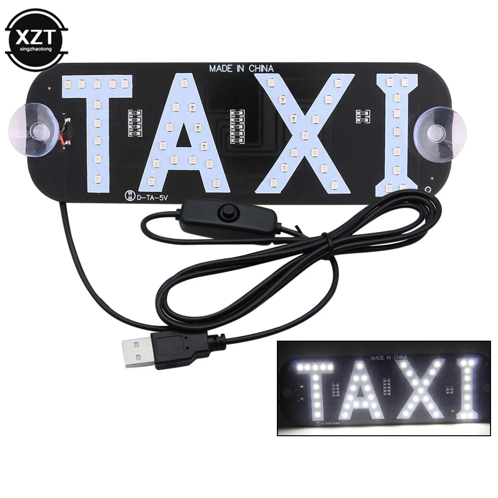 A black LED taxi indicator light panel with the word TAXI illuminated on it, connected to a power cable and adapter.
