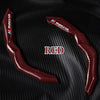 Red carbon fiber steering wheel cover displayed on a black textured surface.
