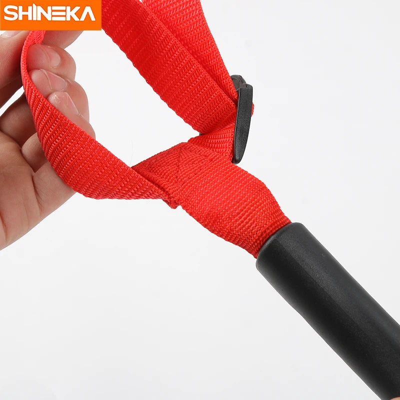 A close-up of a red nylon grab handle with a black grip, used for securing off-road vehicle roll bars.