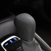 Close-up of a black gear shift knob cover on a car steering column.